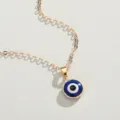 Macro view of a blue Turkish Evil Eye pendant on a gold-plated chain necklace detail. - Minimalist Gold Round Eye Style (NC21Y0416-2)
