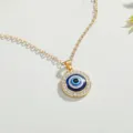 Detailed macro view of the blue Evil Eye pendant necklace with sparkling crystal accents - Gold Round Eye Rhinestone Inlaid Style (NC21Y0418-1)