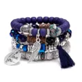 Detailed close-up of bohemian layered gemstone and metal wing charm bracelet set details showcase. - Sapphire Blue