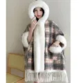 Nahaufnahme des karierten Ponchos mit Kapuze, weißem Kunstpelzbesatz und Fransen - Morgenmantel / Kreuzkaro Grau Fleece