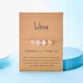 Handgefertigtes Waage-Sternzeichen-Armband mit rosa Natursteinen auf brauner Karte - Waage
