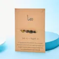 Handgefertigtes Löwe-Armband mit Natursteinen auf brauner Sternzeichen-Karte - Löwe