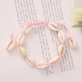Detail view of handmade pink woven cowrie shell bracelet for summer beach vacations. - Pink Braided Rope with White Natural Shell (BR23Y0237-4)