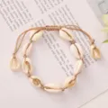 Detailed view of woven shell bracelet with natural cowrie shells and adjustable beige cord - Beige Braided Rope with Natural White Shell (BR23Y0237-6)
