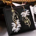 Elegant artistic gold-tone face silhouette earrings decorated with white floral petals - Asymmetric Face Outline Petal (ER21Y0010)