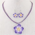 Nahaufnahme eines lila Frangipani-Halsketten- und Ohrring-Sets auf einer weißen Büste - Lila