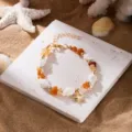 Bohemian summer beach bracelet featuring orange gravel, shells, and a golden starfish - Bracelet / Brown