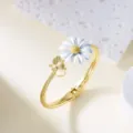Elegant gold-plated bangle bracelet featuring a white lacquer daisy and bee charm detail - Bangle / White