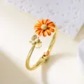 Elegant gold-tone bangle bracelet featuring orange enamel daisy and honeybee accents - Bangle / Orange