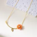 Korean style daisy necklace with orange flower and gold leaf charm on white textured stone - Necklace / Orange