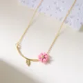 Elegant gold chain necklace with a pink daisy pendant and a gold leaf charm - Necklace / Pink