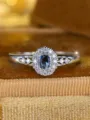 Macro detail of a sapphire blue oval zircon ring featuring halo diamond setting on a silver band - Size 6 / Oval Halo Hollow Style / Platinum Blue