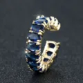 Detailopname van een gouden open ring bezet met ovale blauwe zirkonia-stenen - Verstelbaar Open / Vergulde Saffierblauw Zirkoon