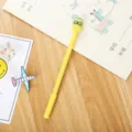 Creative yellow gel pen with cute cartoon pineapple topper shown on a wooden desk - Pineapple Style (LJF26) / 0.5mm Pen Point