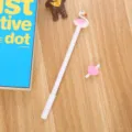 Cute white gel pen with a pink flamingo topper on a wooden desk - 0.5mm / White