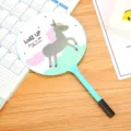 Cute cartoon unicorn fan ballpoint pen displayed on a wooden desk with a calendar backdrop - Blue