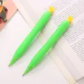 Deux porte-mines créatifs vert en forme de fruit avec étoiles jaunes sur un livre - Style Concombre à Fleur Jaune