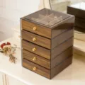 Detailed view of a five-layer wooden jewelry box with clear acrylic lid and gold knobs. - 5层胡桃木