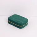 Close-up view of a green quilted velvet travel jewelry box featuring a gold zipper closure - 16.5x11.5x5cm / Dark Green