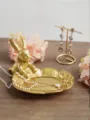 Detailed macro view of vintage golden rabbit jewelry tray with pearl necklace on wood - Sitting Rabbit / Gold