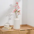 Vue détaillée d'une branche de fleurs de prunier lilas artificiel dans un vase blanc, déco. - Rose foncé