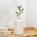 Künstliche kurze Rosenblüte mit weißer Keramikvase für Schreibtischdekoration und Fotorequisite. - Grau