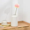 Artificial pink anthurium flower in a modern white ceramic vase for home decor detail view. - Pink Yellow