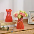 Roter Kunststoff gewebter Blumenvasen mit Schleife und künstlichen Rosen für Dekoration. - Rot