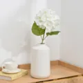 Artificial white hydrangea flower arrangement in ceramic vase, elegant home decor detail shot. - White