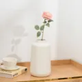 Künstliche rosa Rose in weißer Keramikvase für die Tischdeko im Wohnzimmer zu Hause - Fleischrosa