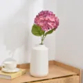 Detailed close-up view of a pink artificial hydrangea flower branch in a white vase setup. - Rose Purple