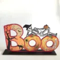 Decorazione da tavolo in legno di Halloween cartello BOO con simpatico scheletro e zucca. - Stile M