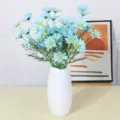 Blauer künstlicher Gänseblümchenstrauß in weißer Keramikvase für Heimdeko und Fotografie. - Blau