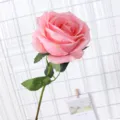 Künstliche einzelne rosa Rose mit Stiel und grünen Blättern für Heimdekoration und Party. - Korallenrosa