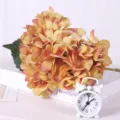 Artificial hydrangea flower branch with dual leaves, vibrant orange gradient floral decor. - Mud Yellow
