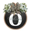 Dettaglio cartello porta rotondo in legno con fiocco bianco nero, verde e testo di benvenuto. - 30*30cm / Lettera O