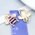 Pink and black enamel bee pendant charm with KC gold plating shown on scale ruler - Enamel Printed Bee (27606) / 1 Piece/Pack (19*18mm) / Pink