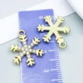 Macro view of gold and rhinestone snowflake charms for jewelry making with size scale - Rhinestone Christmas Snowflake (27007) / 1 Piece (21*16mm) / KC Gold