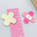 Pink enamel band-aid charms with medical cross, displayed with ruler for size reference - 1 Piece (21*21mm)