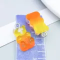 Close-up of two gradient orange and yellow resin gummy bear charms on a measurement display card - Bear Candy (12566)