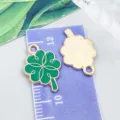 Grüner Emaille-Kleeblatt-Anhänger im Detail mit Größenangabe auf dem Zentimetermaß - St. Patrick's Vierblättriges Glücksklee (25095)