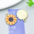 Colorful enamel sunflower alloy charms for DIY jewelry making displayed on a ruler - Yellow-Orange Thanksgiving Sunflower (19209)