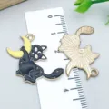 Black enamel Halloween cat and moon pendant charm shown with a measuring ruler - Cat Holding Moon (18134) / 1 Piece/Pack (30*26mm) / Black
