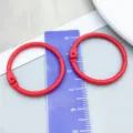 Vibrant red painted metal binder ring displayed with ruler for size and scale reference - Red Painted (26248) / 1 Piece (30mm/25mm)