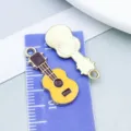 Gelber und brauner Gitarren-Emaille-Anhänger aus Legierung für DIY-Schmuck und Basteln - Musikinstrument Gitarre (19470) / 1 Stück (23x10mm) / Gelb