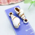 Deux breloques coquillage en acrylique marron et blanc pour bijoux DIY sur une règle. - Conque Spirale Longue (27370) / 1 Pièce (23x9mm) / Brun et Blanc