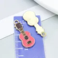 Gitarren-Anhänger aus Emaille für DIY-Schmuckherstellung auf lila Zentimetermaß - Musikinstrument Gitarre (19471) / 1 Stück (23x10mm) / Fuchsia