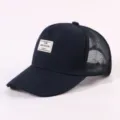 Nahaufnahme Detail der dunkelblauen Trucker Baseballcap mit stylischem Stoffaufnäher. - Verstellbar / Marineblau