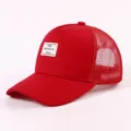 Nahaufnahme der roten Trucker-Cap mit atmungsaktivem Mesh und Brooklyn-Etikett. - Verstellbar / Rot