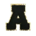 Detail shot of black chenille letter A patch featuring sparkling gold sequin border design. - Letter A